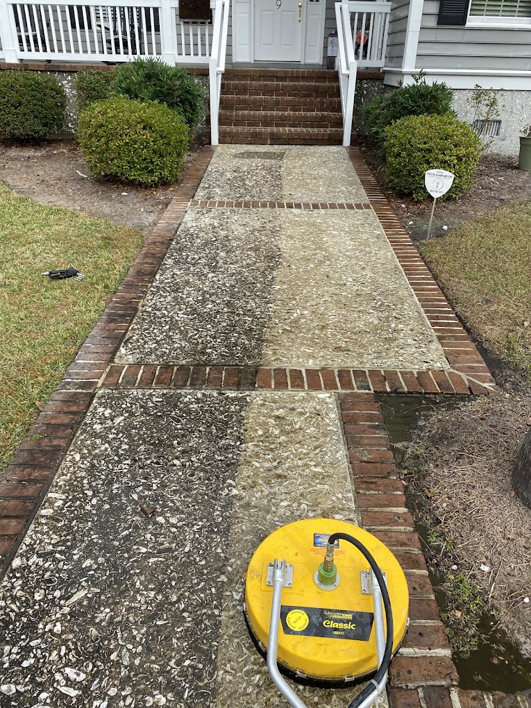 Walkway surrounded by brick and a lawn being surface cleaned